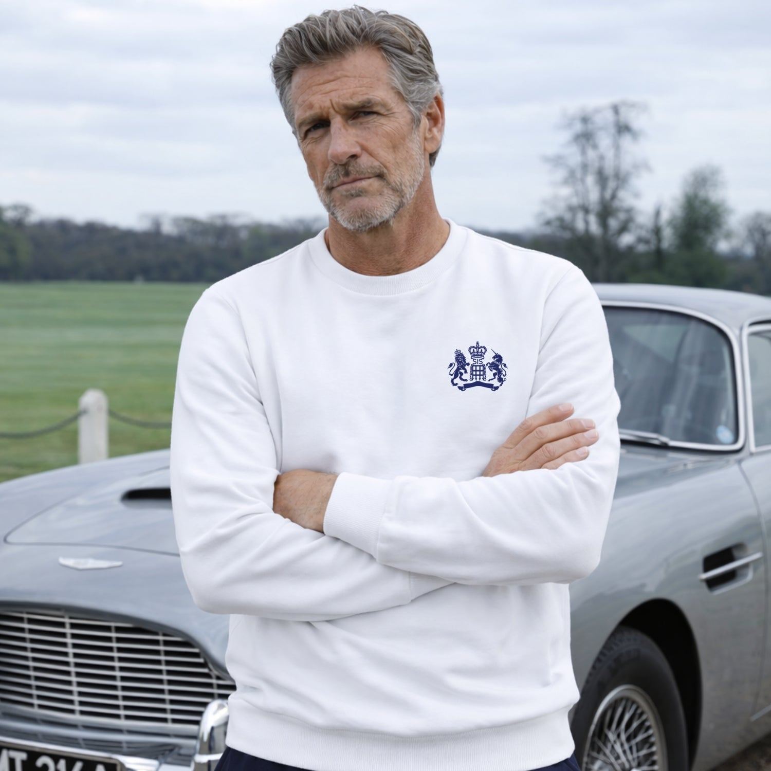 Man wearing James Bond Luxury Sweatshirt in White standing next to Aston Martin DB5