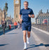 Man running on a bridge with Big Ben in the background