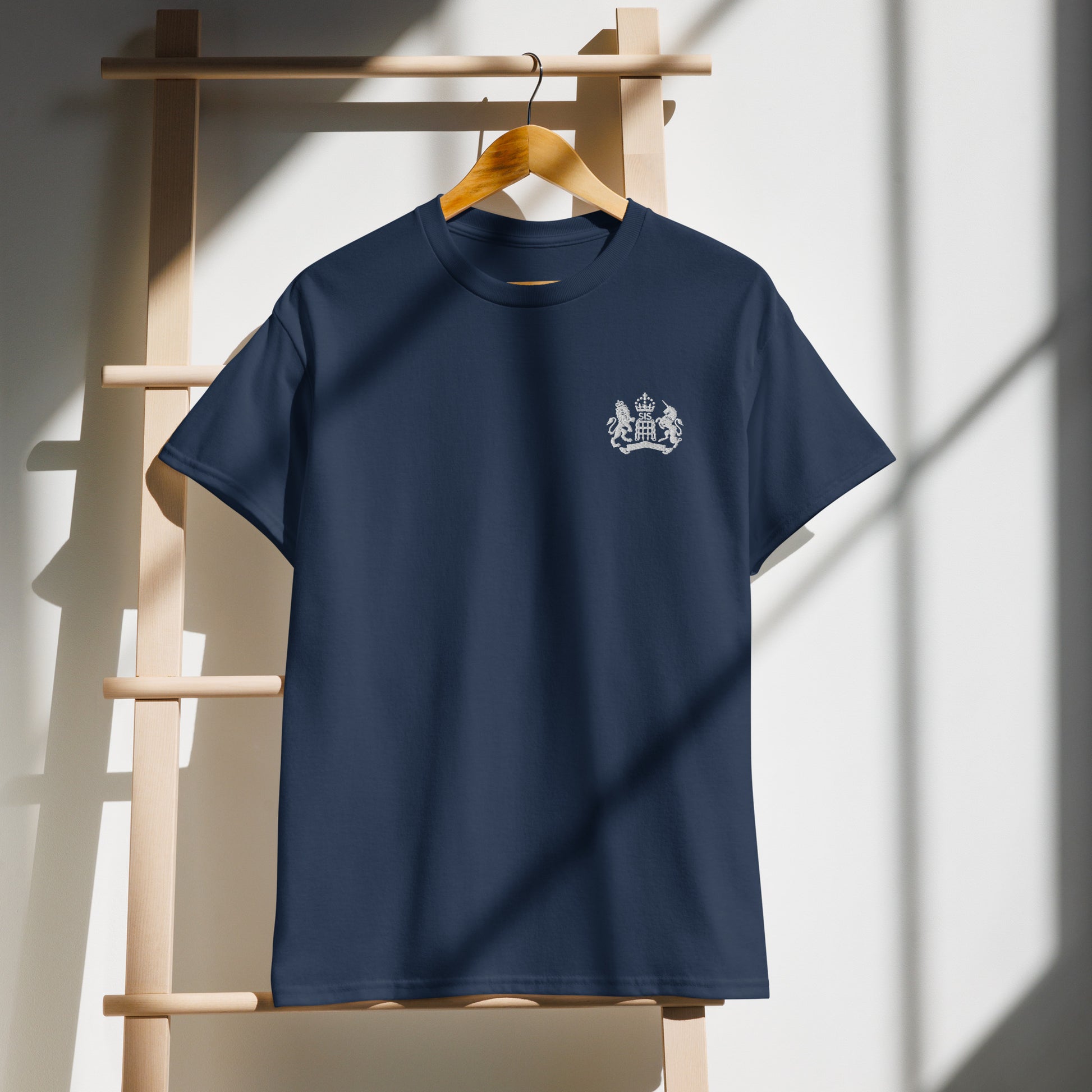 Navy blue t-shirt with a white logo on a wooden hanger against a light background with Updated UK King's Crown Logo 