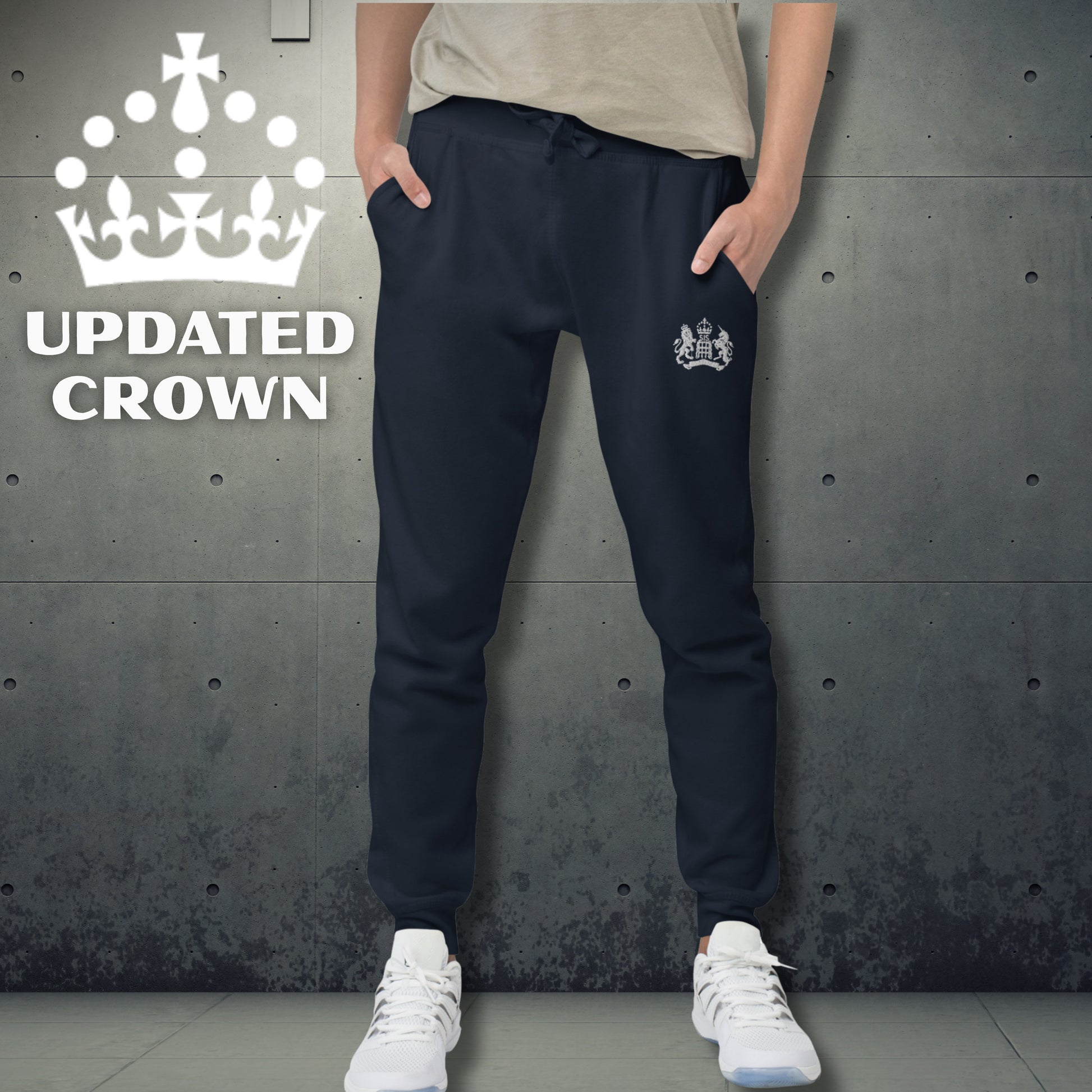 Person wearing navy jogger pants with a logo, standing against a textured gray wall with 'Updated UK King's Crown' branding.